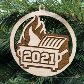 Engraved dumpster fire ornament on greenery