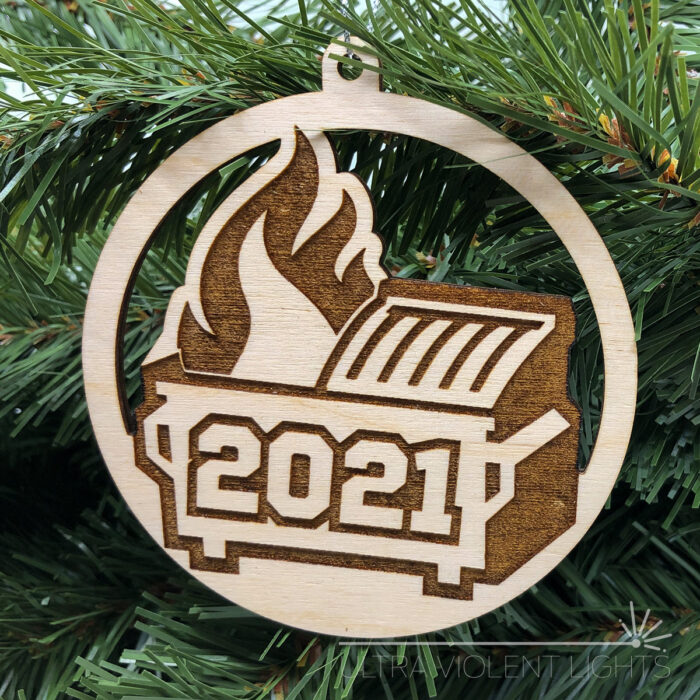 Engraved dumpster fire ornament on greenery